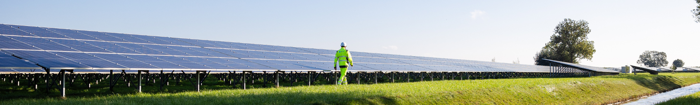 Uomo che cammina accanto a un pannello fotovoltaico